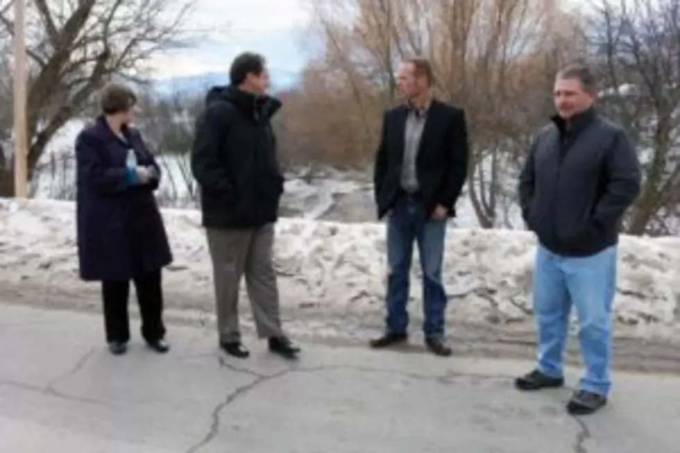 From left to right, Commissioner Jean Curtiss, Gov. Steve Bullock, Bill Lloyd from Great West Engineering, and Erik Dickson, director of Public Works, tour the Mill Creek crossing in Frenchtown. (Martin Kidston/Missoula Current)