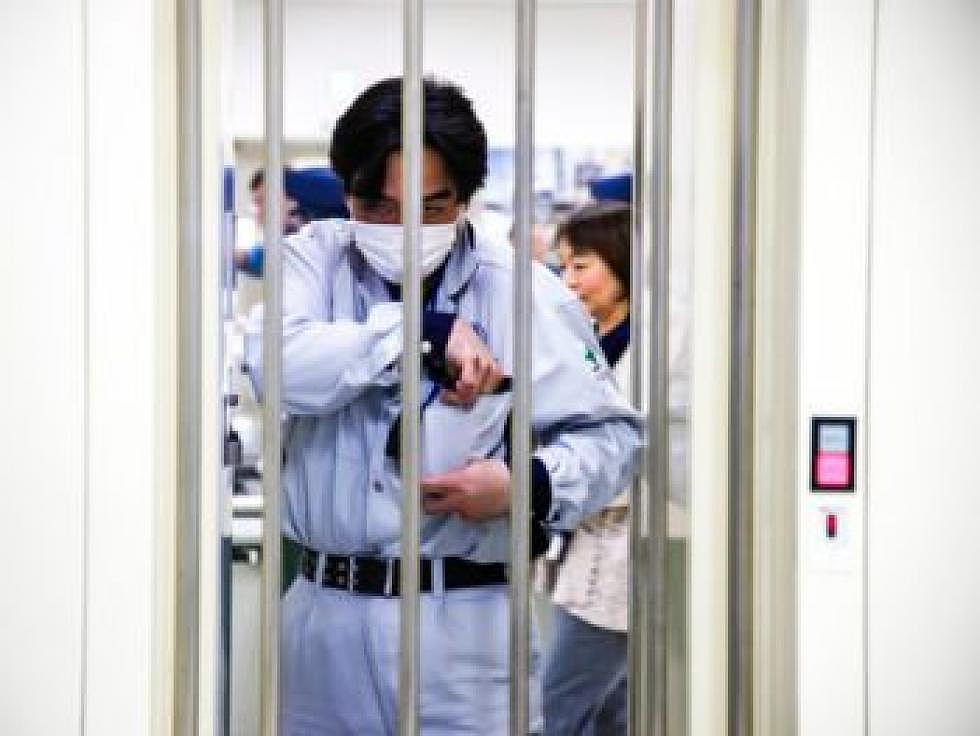 <em>TEPCO security guards screen employees coming in and out of the power station facility. The daily security routine includes a metal detector, bag screening and an ID check before entrance is permitted into the facility. (Sydney MacDonald)</em>