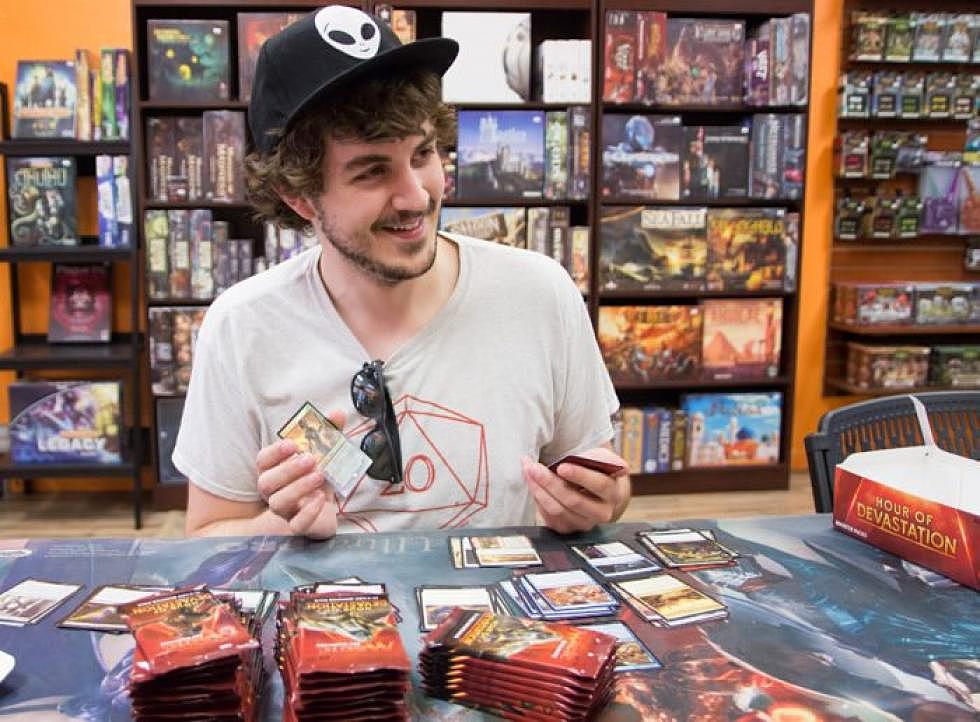 <em>Lucas Hawksley shows off a very rare card he just discovered in a new pack of Magic: The Gathering cards in Retrofix. (Katy Spence/Missoula Current)</em>