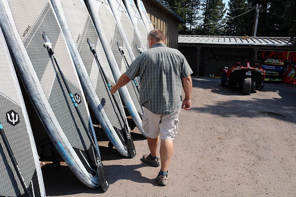 Moose Jergensen inspects the recreational gear that isn't renting due to the closure of Seeley Lake and other area attractions due to the Rice Ridge fire. (Martin Kidston/Missoula Current)
